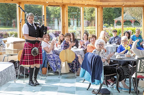 Piper entertaining guests at a tea party in Brechin