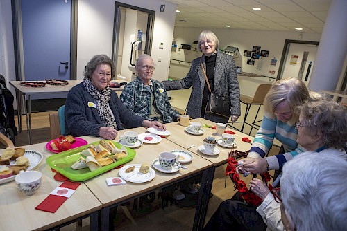 Tea party guests in Stirling enjoying refreshments and making poppy wreaths