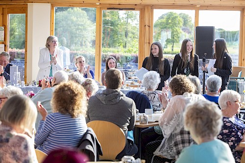 Students talking to tea party guests in Brechin