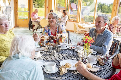 Tea party guests being offered cakes in Brechin