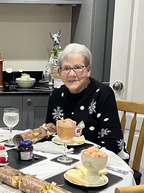 Rosemary sat at a table with food and drink