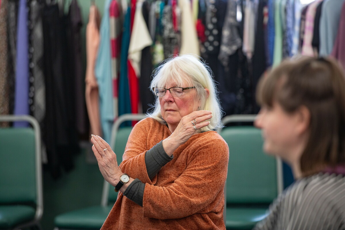 Two people sat doing a gentle exercise activity group