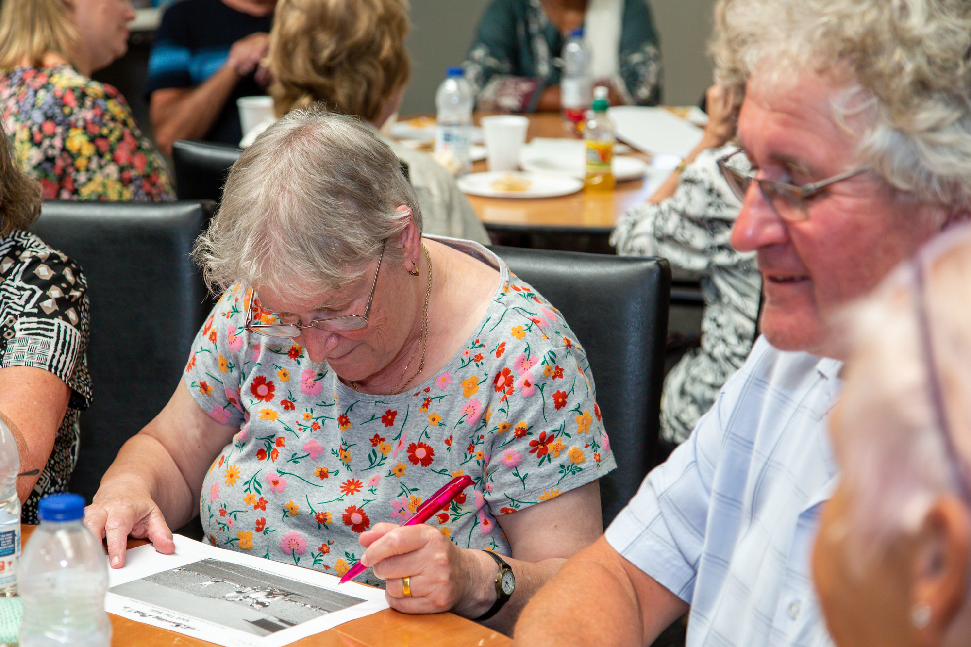 A group of people sat around a table taking part in an activity group