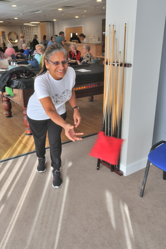 A woman tossing a bean bag